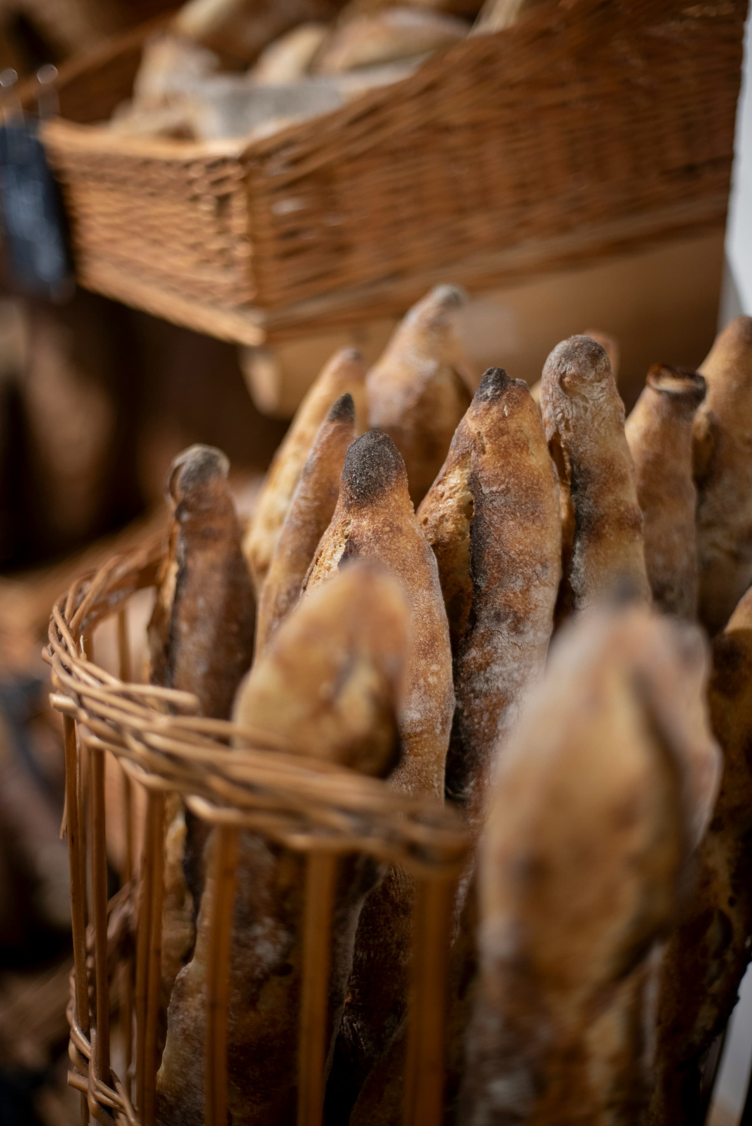 Artisan baguettes standing in wicker baskets at a local bakery